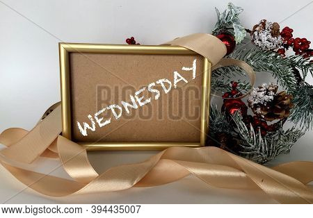 Wednesday On Craft Paper In A Frame On A White Background.next To The Spruce Branches,berries ,ribbo