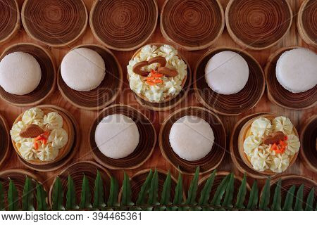 White Delicate Lowly Macaroons On A Wooden Background. The Pastel Tone Of The Cream Inside The Frenc