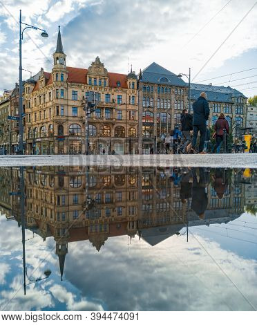 Wroclaw October 10 2019 Old Tenement Houses Shops And Walking People Reflected In Puddle