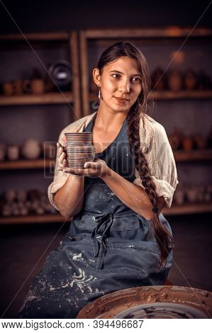 Artisan Woman Shows The Finished Clay Product In Workshop. Restoration Of Forgotten Pottery Traditio
