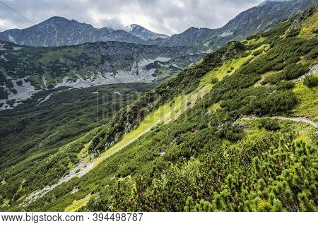 Tourists In Western Tatras Mountains, Slovak Republic. Hiking Theme. Seasonal Natural Scene.