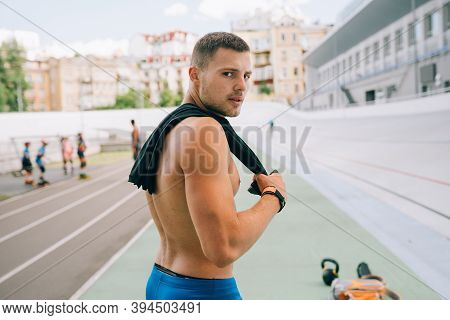 Young Muscular Guy With A Naked Torso Looking Back Over His Shoulder.