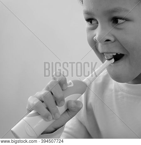 Little Boy Brushing His Teeth With An Electric Tooth Brush Stock Image With Grey Background Stock Ph