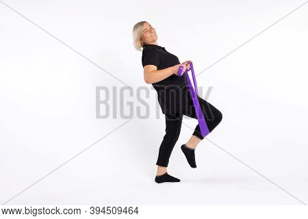 Senior Woman Doing A Fitness Workout At Home Using An Elastic Band. Photo On A White Background. Hea
