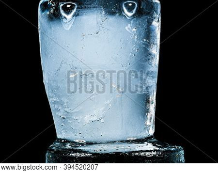 Ice Melts And Rotates On A Black Background. Extreme Close Up. Crystal Ice Cube With Frozen Water Th