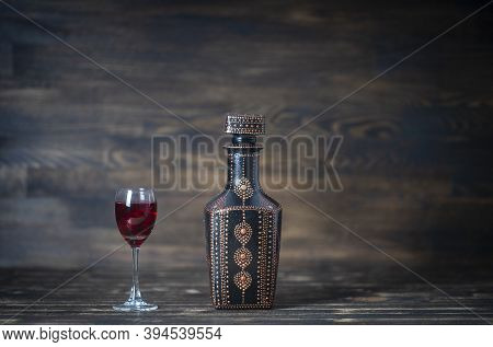 Homemade Tincture Of Red Cherry In A Decorative Bottles And A Wineglass On Wooden Background, Ukrain