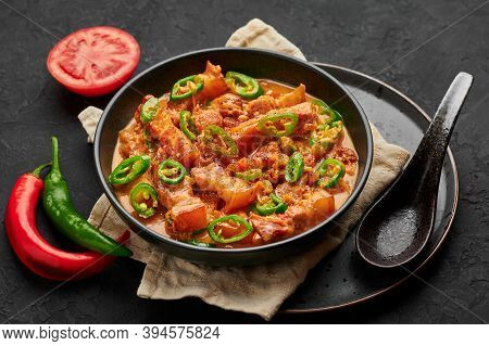 Bicol Express Stew In Black Bowl On Dark Slate Table Top. Filipino Cuisine Spicy Pork Belly Coconut