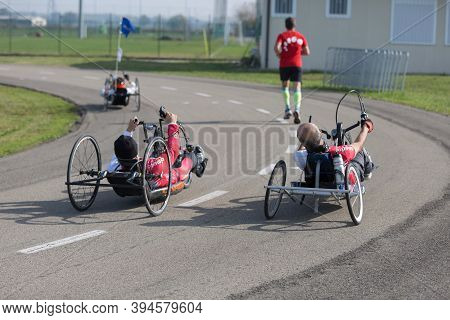 Parma, Italy - October 2020: Disabled Athletes Training With Their Handbike With Runner Close To The