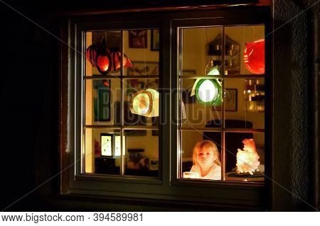 Little Kid Girl Sitting By Window With Selfmade Hand Crafted Lanterns With Candles For St. Martin. L