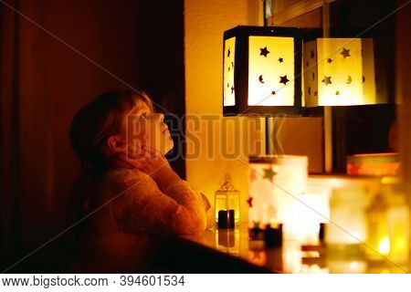 Little Kid Girl Sitting By Window With Selfmade Hand Crafted Lanterns With Candles For St. Martin Pr
