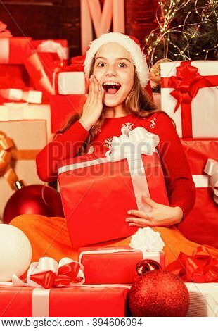 Kid In Santa Hat With Many Gift Boxes. Successful Shopping On Xmas Market. Decorated With Gifts. Sho
