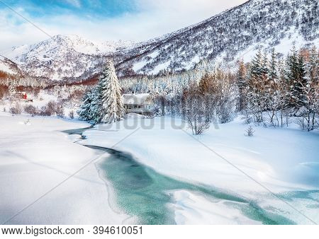 Fabulous Winter Scenery With Frozen River With Wooden Houses And Snow Covered Pine Trees Near Valber