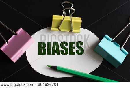 Biases - Word On White Paper With Multicolored Clips And Green Pencil. Business Concept
