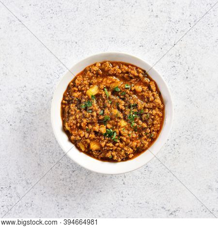 Close Up View Of Keema Curry In Bowl Over Light Stone Background With Copy Space. Indian And Pakista