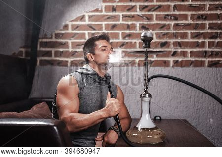 Sexy Man Enjoy Aromatic Shisha In Nightclub.