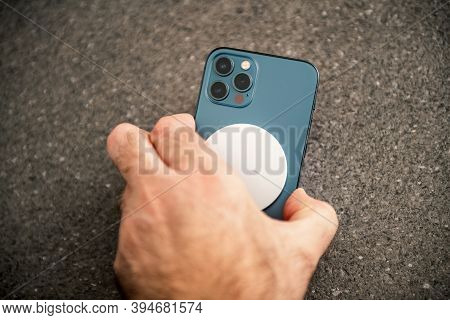Paris, France - Nov 11, 2020: Man Placing Charging Device Magsafe Wireless Charger The Latest Iphone