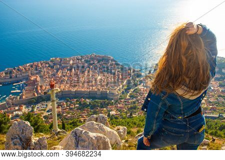 Over The Shoulder View Of A Girl Standing On Top Of The Srd Mountain, Looking Down On Dubrovnik City