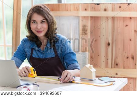 Beautiful Asian Adult Woman Wearing Jeans Clothes Working As A Carpenter In Room At Home. Concept Fo