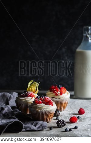 Homemade Muffin Next To A Bottle Of Milk On A Table And On A Dark Background With Fresh Berries Arou