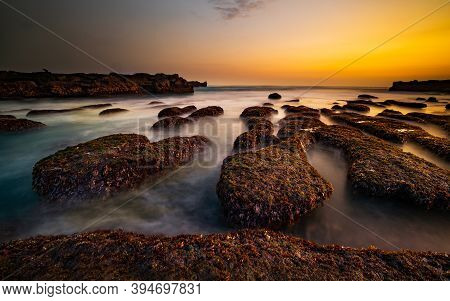 Amazing Seascape For Background. Beach With Rocks And Stones. Low Tide. Motion Water. Clear Sky. Sun