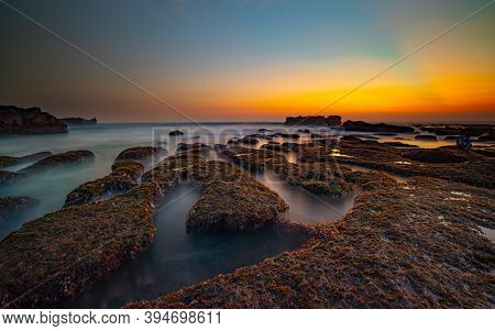 Amazing Seascape For Background. Beach With Rocks And Stones. Low Tide. Motion Water. Clear Sky. Sun