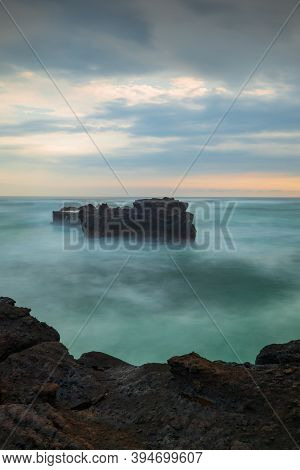 Picturesque Seascape. Amazing Landscape. Rock In The Ocean. Motion Waves. Silky Water. Long Exposure