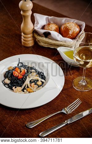 Black Spaghetti. Spicy Black Seafood Pasta With Squid With Basil On Wooden Table.