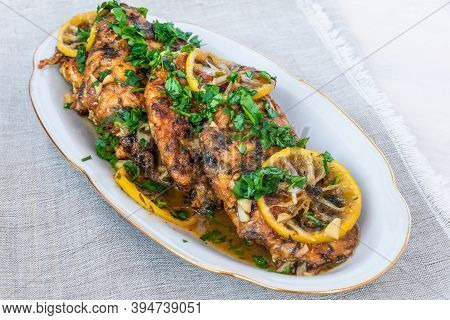 Chicken Francese - Fried Chicken Breast With Lemon Slices And Delicious Sauce On A White Plate Close