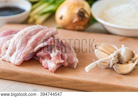 Ingredients For Making Asian Lunch - Raw Pork Belly, Garlic, Onion And Rice