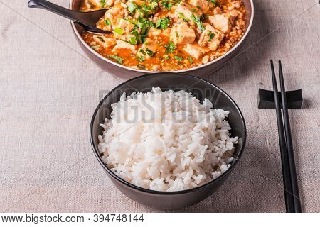 Traditional Chinese Sichuan Cuisine - A Bowl Of Rice And Mapo Tofu In A Large Plate On A Rustic Tabl