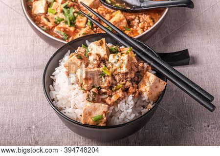 Traditional Chinese Sichuan Cuisine - A Bowl Of Rice With Mapo Tofu On A Rustic Background