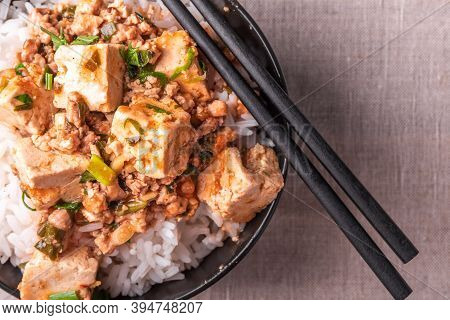Traditional Chinese Sichuan Cuisine - A Bowl Of Rice With Mapo Tofu On A Rustic Background