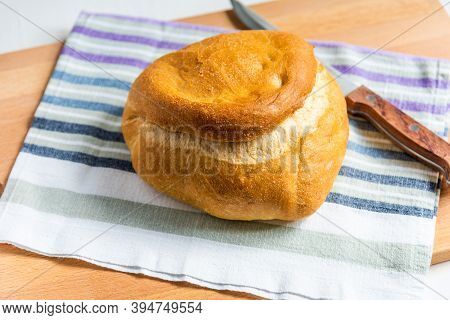 A Loaf Of Homemade Wheat Bread On A Rustic Striped Kitchen Towel And A Knife With A Wooden Handle, T