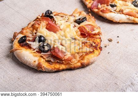 Traditional Italian Appetizer - Mini Pizza, Pizzetta With Jamon On A Linen Napkin Close-up - Roman S