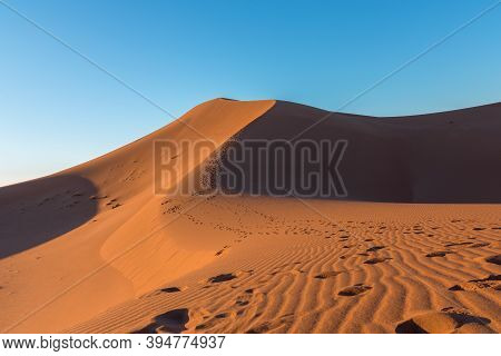 Wide Angle Shoot Of Footpath In Desert Dunes Of Erg Chigaga.the Gates Of The Sahara, At Sunrise. Mor
