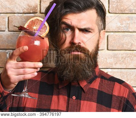 Barman With Beard And Strict Face Holds Glass With Cocktail.