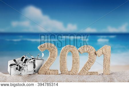 New Year 2021 On The Beach. Snowman And Christmas Gifts In The Sand