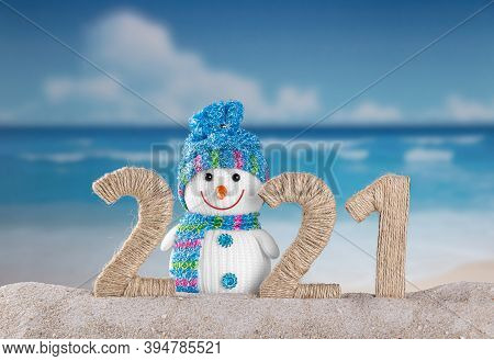Concept Of The New Year In Hot Countries. Traditional Snowman In Sand In Inscription 2021 On Backgro