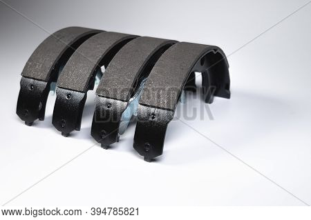 New Set Of Four Brake Pads For Drum Brakes On A Gray Background