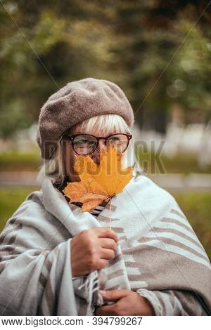 Beauty Romantic Blonde Woman Enjoying Nature Holding Leaves In Hands Outdoors