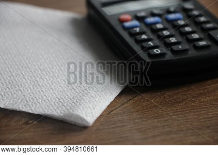 White Napkin And Calculator On Wooden Table. Accounting Business Concept