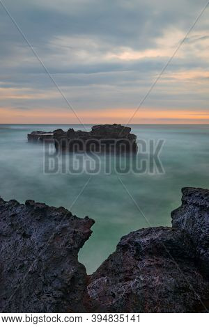 Picturesque Seascape. Amazing Landscape. Rock In The Ocean. Motion Waves. Silky Water. Long Exposure