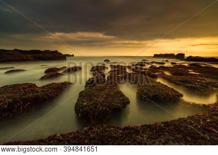Amazing Seascape For Background. Beach With Rocks And Stones. Low Tide. Motion Water. Cloudy Sky. Sl