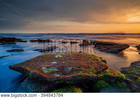 Beautiful Seascape. Beach With Rocks And Stones. Low Tide. Big Flat Stone Covered By Seaweeds. Motio