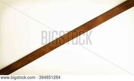 Brown Leather Strap On A White Background. Bright Diagonal Stripe.