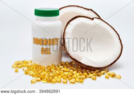 Health Care - Nutritional Supplement - Bottle Of Coconut Oil With Halved Coconut On The Side And Sca
