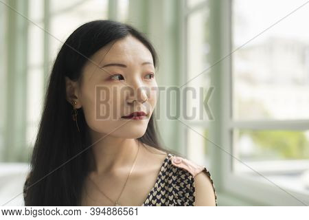 A Chinese Woman Looking Out A Window Inside A Sitting Room Within The Walters Art Museum In Baltimor