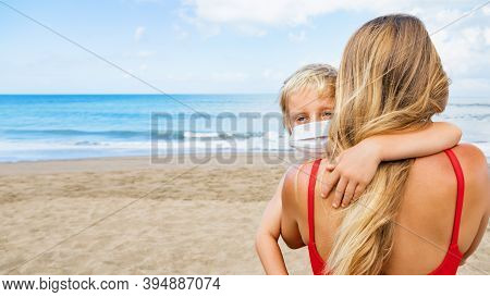 Mother Put Medical Mask On Child On Sea Beach. New Rules To Wear Cloth Face Covering At Public Place