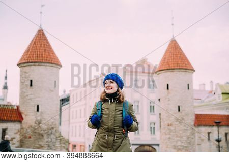 Tallinn, Estonia. Young Caucasian Girl Woman Backpacker Enjoying And Smiling Near Famous Landmark Vi