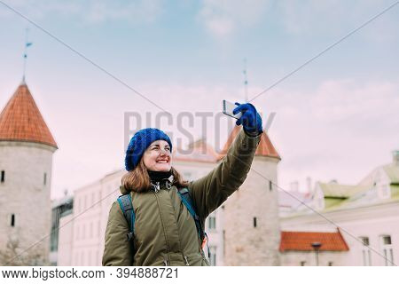 Tallinn, Estonia. Young Caucasian Girl Woman Backpacker Tourist Enjoying Life, Smiling, Call, Having